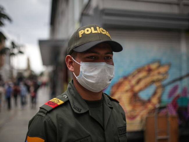 Un funcionario policial colombiano utiliza mascarilla mientras cumple sus labores