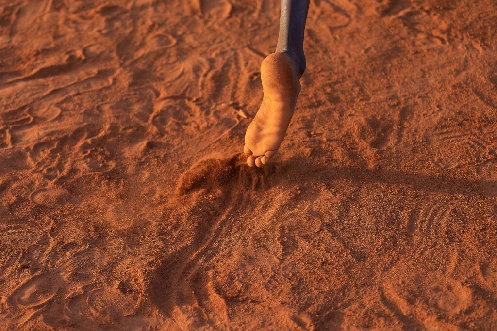 Niño juega en la tierra en un torneo de béisbol en Uganda