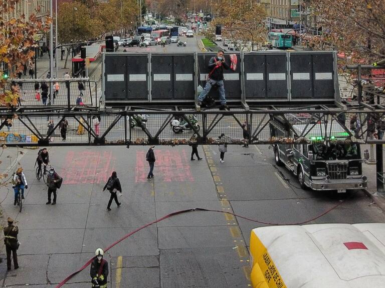 Hombre que protestaba arriba de una señalética de tránsito fue bajado por Carabineros