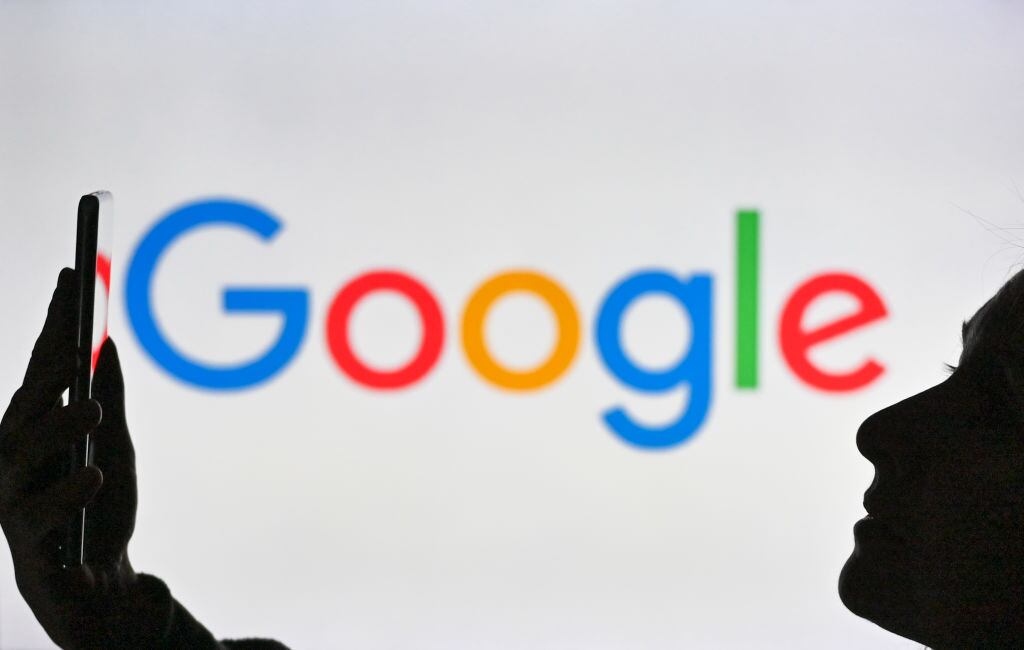 Un smartphone ante el logo de la plataforma Google