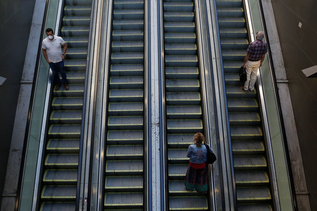 SANTIAGO, CHILE - MARCH 24: People take escalators keeping their distance during the Covid-19 pandemic on March 24, 2020 in Santiago, Chile. The "state of catastrophe" declared by president Sebastian Piñera gives the government extraordinary powers to restrict freedom of movement and assure food supply and basic services for 90 days to confront the spread of COVID-19.  (Photo by Marcelo Hernandez/Getty Images)
