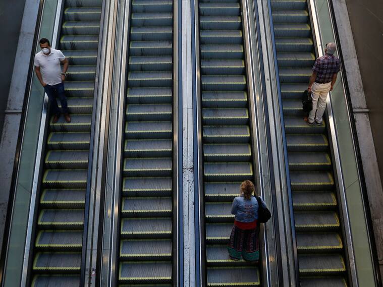 SANTIAGO, CHILE - MARCH 24: People take escalators keeping their distance during the Covid-19 pandemic on March 24, 2020 in Santiago, Chile. The "state of catastrophe" declared by president Sebastian Piñera gives the government extraordinary powers to restrict freedom of movement and assure food supply and basic services for 90 days to confront the spread of COVID-19. (Photo by Marcelo Hernandez/Getty Images)