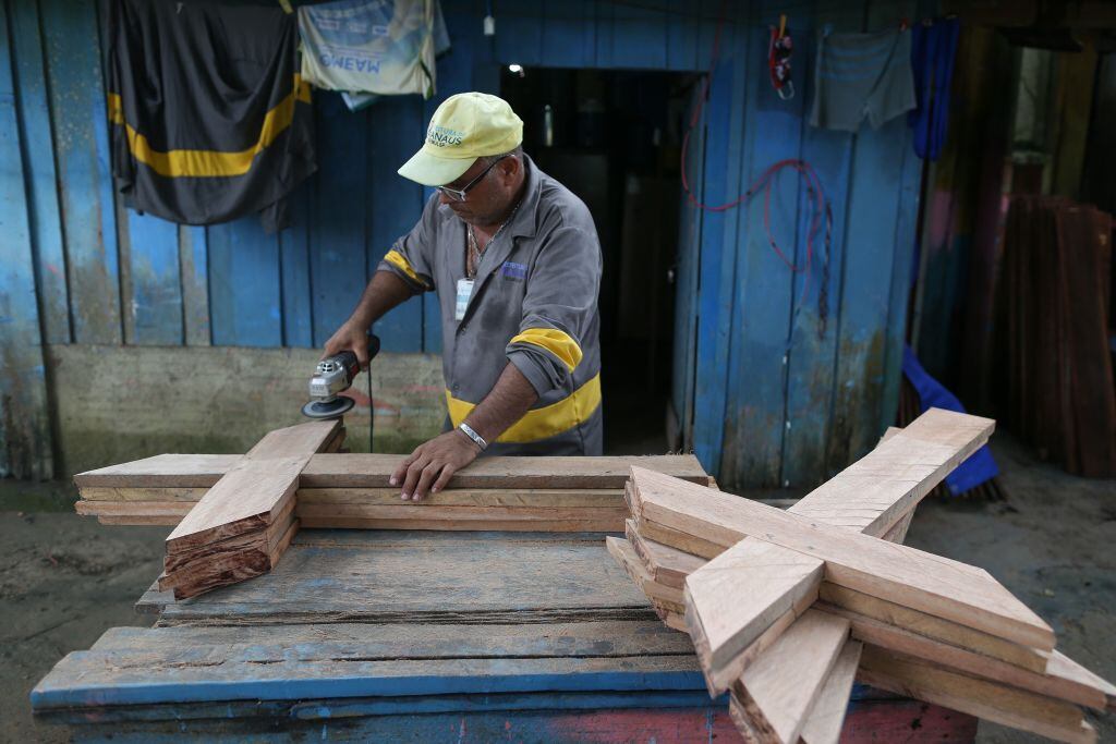 El trabajador de un cementerio fabrica cruces de madera en Manaos
