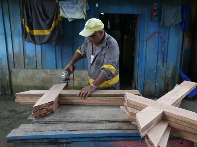 El trabajador de un cementerio fabrica cruces de madera en Manaos