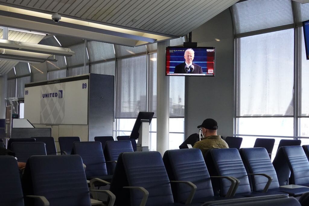 Un usuario del aeropuerto de Chicago observa el discurso de Biden
