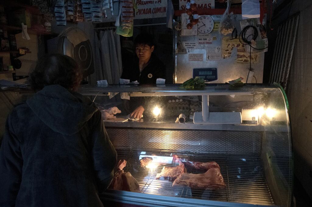 Un comerciante atiende a la luz de las velas en la capital de Argentina