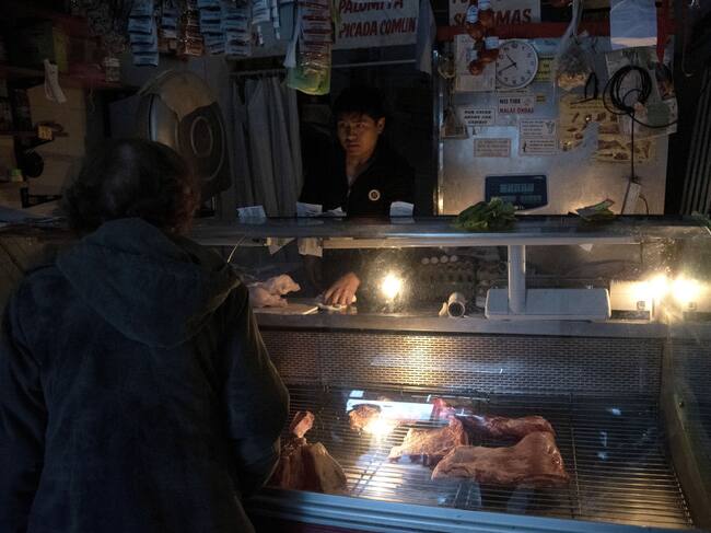Un comerciante atiende a la luz de las velas en la capital de Argentina