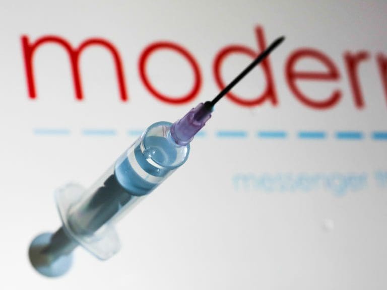 Medical syringe is seen with Moderna company logo displayed on a screen in the background in this illustration photo taken in Poland on June 12, 2020. American biotech company Moderna has announced on June 11 that will start final stage of covid-19 vaccine trial in July. (Photo Illustration by Jakub Porzycki/NurPhoto via Getty Images)