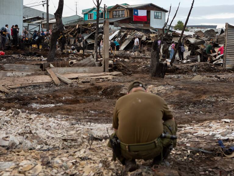 10 DE DICIEMBRE 2021 / CASTROUn carabinero agachado revisa los escombros tras incendio forestal que destruyo más de 140 casas en la población Camilo Henrriquez y Villa los Presidentes, durante mega incendio en la ciudad de Castro, Chiloé.
FOTO: FELIPE CONSTANZO / AGENCIAUNO