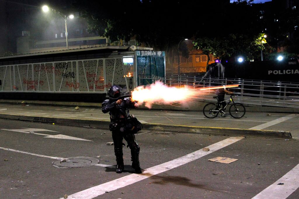 Un policía dispara contra los manifestantes durante el paro en Medellín