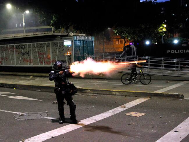 Un policía dispara contra los manifestantes durante el paro en Medellín