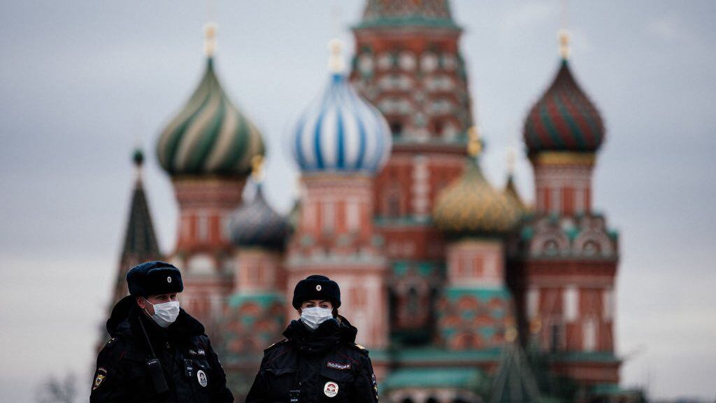 TOPSHOT - Russian police officers patrol on March 30, 2020 on the deserted Red square in front of Saint Basil's Cathedral in Moscow as the city and its surrounding regions imposed lockdowns today, that were being followed by other Russian regions in a bid to slow the spread of the COVID-19 infection caused by the novel coronavirus. - The enforcement of the strict new rules, which Moscow Mayor suddenly announced for the capital late Sunday, coincide with the beginning of a "non-working" week declared by Russian President the week before. (Photo by Dimitar DILKOFF / AFP) (Photo by DIMITAR DILKOFF/AFP via Getty Images)