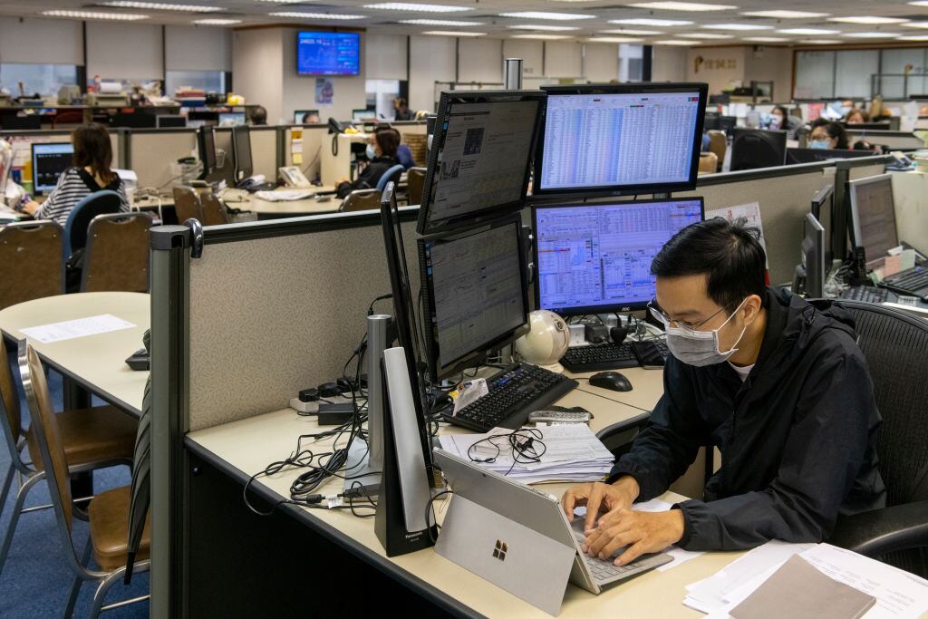 Un trabajador revisa el mercado bursátil en China
