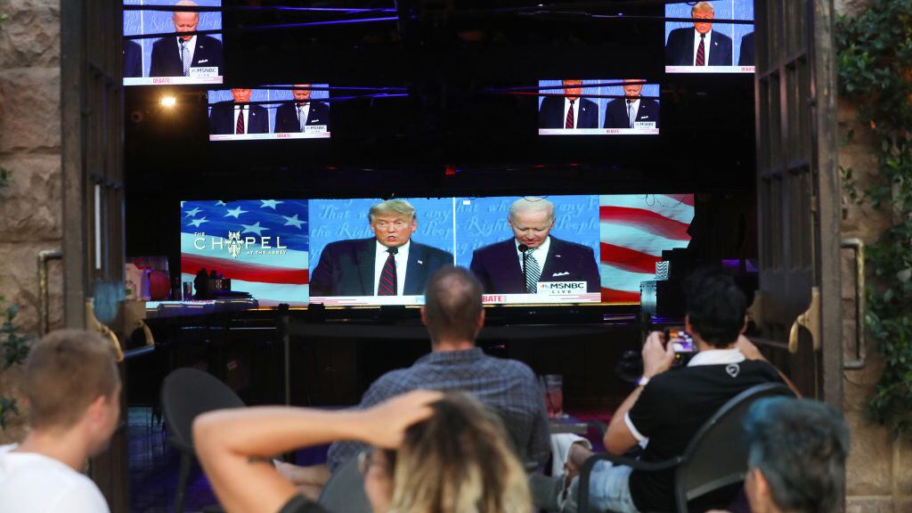 WEST HOLLYWOOD, CALIFORNIA - SEPTEMBER 29: People sit and watch a broadcast of the first debate between President Donald Trump and Democratic presidential nominee Joe Biden at The Abbey, with socially distanced outdoor seating, on September 29, 2020 in West Hollywood, California. The debate being held in Cleveland, Ohio is the first of three scheduled debates between Trump and Biden. (Photo by Mario Tama/Getty Images)