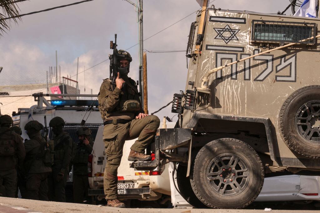 Las fuerzas de seguridad de Israel, totalmente armados, custodian puntos de chequeo en la Cisjordania ocupada de Palestina.