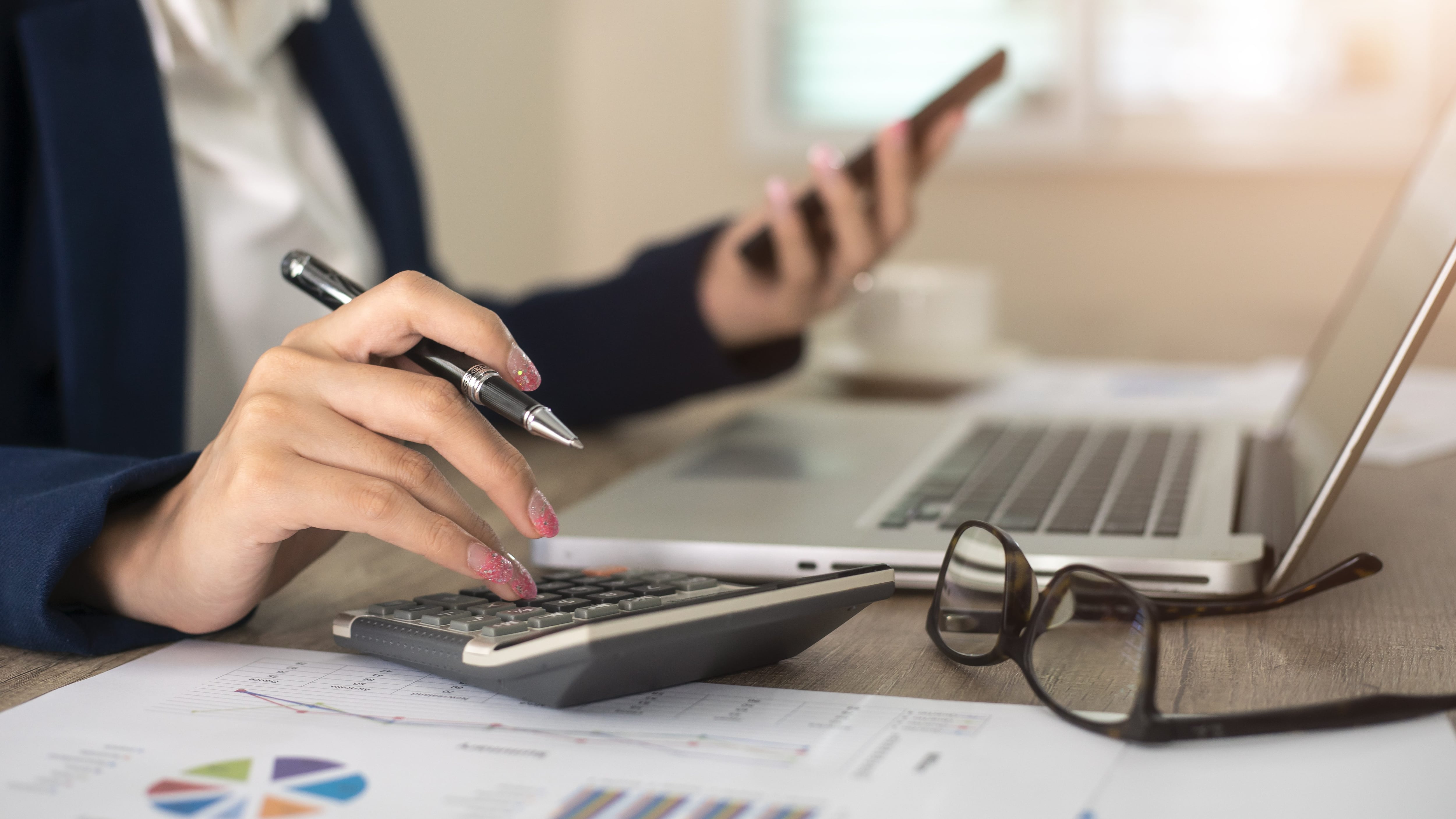 Close up of female accountant or banker making calculations. Savings, finances and economy concept