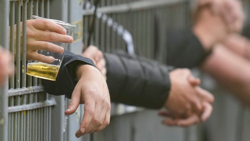 DORTMUND, GERMANY - SEPTEMBER 17: . hands of the fans with a beer behind the fence during the Bundesliga match between Borussia Dortmund and FC Schalke 04 at Signal Iduna Park on September 17, 2022 in Dortmund, Germany. (Photo by Alex Gottschalk/DeFodi Images via Getty Images)