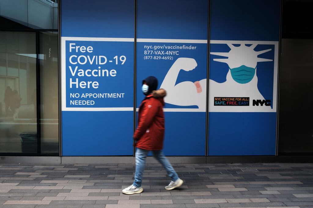 Una persona camina frente a un centro de vacunación anticovid en Nueva York