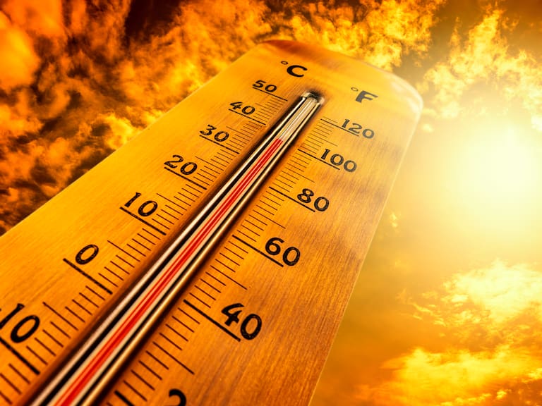 Thermometer showing tropical heat and sky with hot sun rays in Celsius and Fahrenheit