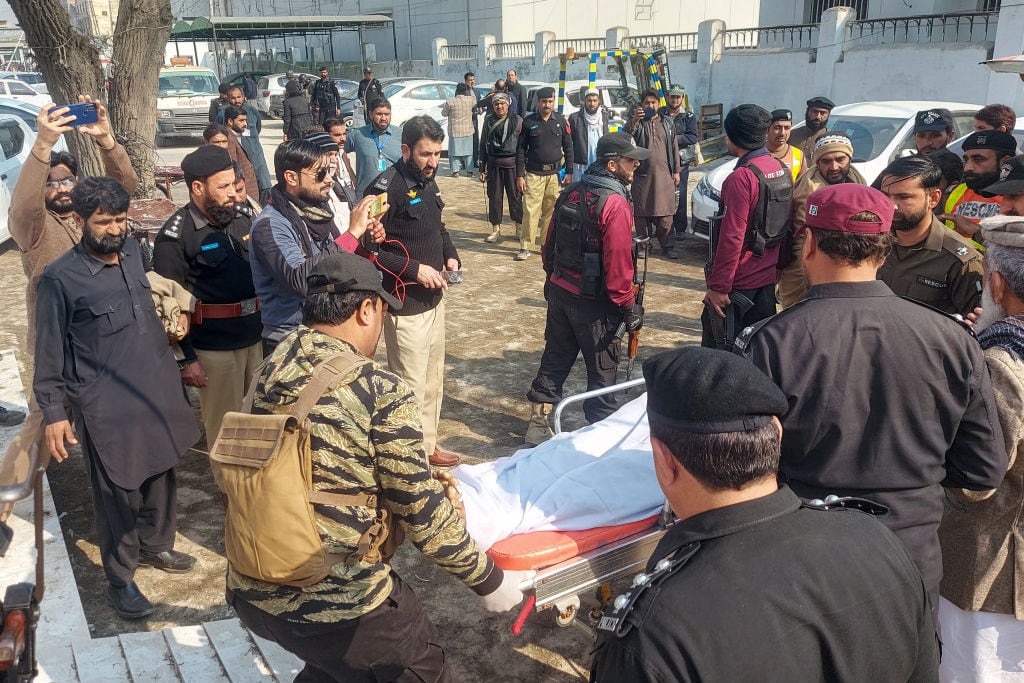 Policías trasladan el cuerpo de un oficial tras el ataque armado ocurrido en una zona fronteriza del norte de Pakistán.