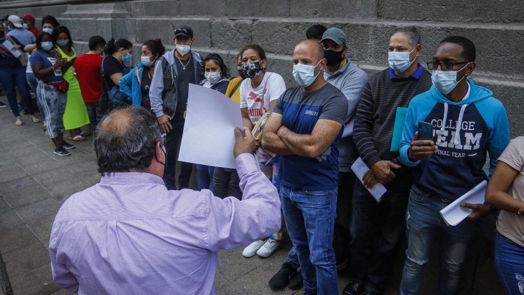 12 de abril del 2021/SANTIAGOUn hombre, llegan a un costado de la Catedral de Santiago, y le explica a las personas migrantes como llenar una solicitud y así entregarlas al subsecretario del Interior, para regularizar su estadía en el país, luego de la publicación de la nueva Ley de Migraciones. 
FOTO: SEBASTIAN BELTRAN GAETE/AGENCIAUNO