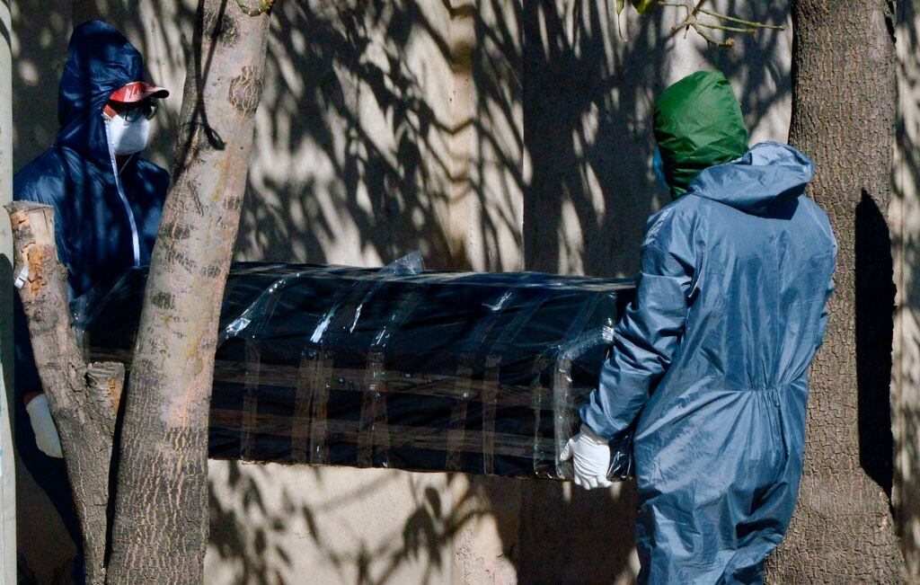 Trabajadores trasladan a una víctima del Covid-19 en Cochabamba