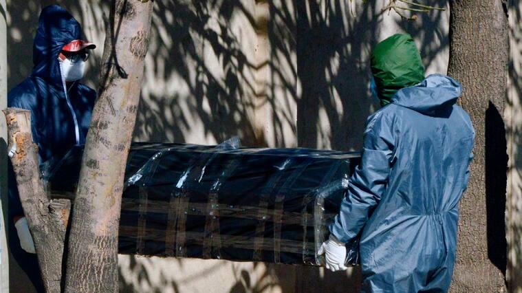 Trabajadores trasladan a una víctima del Covid-19 en Cochabamba