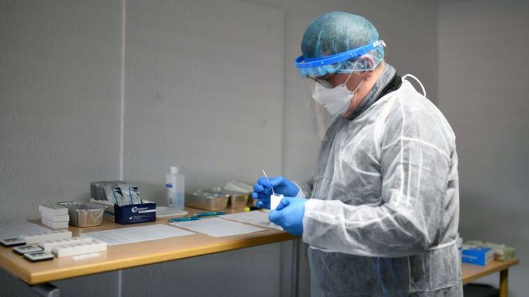 Trabajador de la salud analiza un test del Covid-19 en Alemania