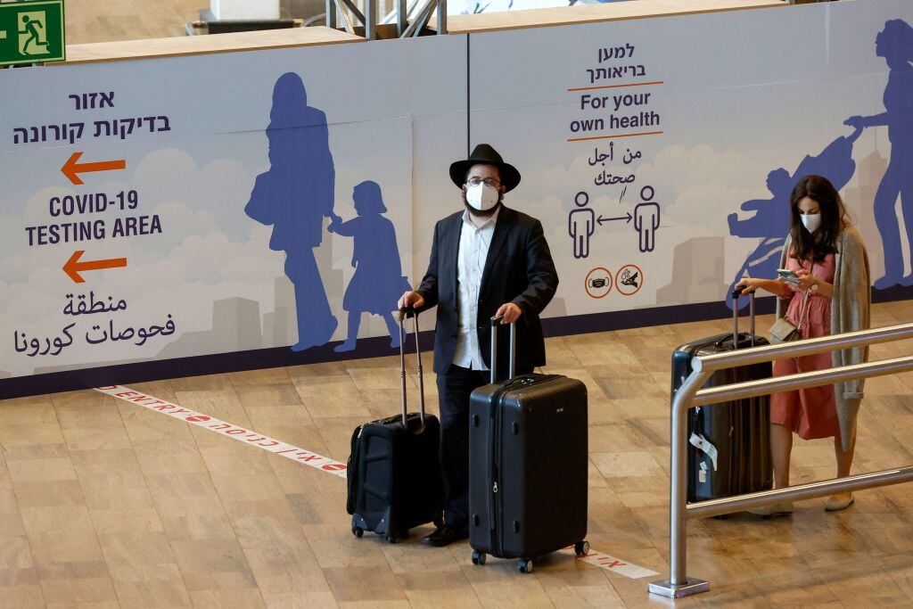 Pasajeros utilizan mascarillas al arribar al aeropuerto de Tel Aviv
