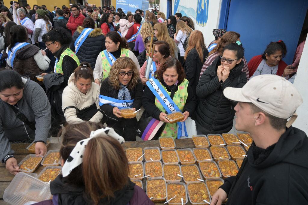 En el Santuario de la Virgen de Caacupé en Ciudad Evita las personas reciben alimentos en un comedor popular en Argentina.