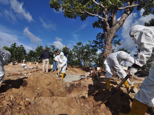 Trabajadores desarrollan un funeral de una víctima del Covid-19 en Indonesia