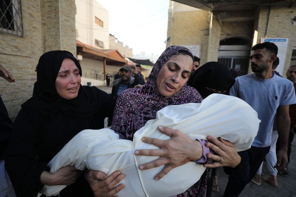 Mujeres lloran la muerte de un niño tras los ataques militares de Israel sobre la Franja de Gaza en Palestina