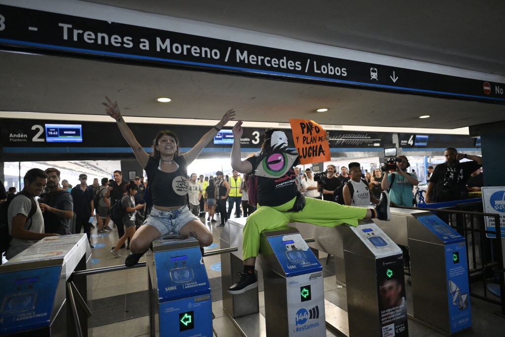 Demonstrators jump the turnstile at the Once train station during a protest against the economic measures of President Javier Milei's government and the increase in public transport fares in Buenos Aires on March 1, 2024. Argentina's self-styled anarcho-capitalist President Javier Milei will make his first policy speech to parliament Friday, facing lawmakers he has described as "rats" and "traitors" for stalling his project of deregulation and budget cuts. (Photo by Luis ROBAYO / LUIS ROBAYO / AFP) (Photo by LUIS ROBAYO/LUIS ROBAYO/AFP via Getty Images)