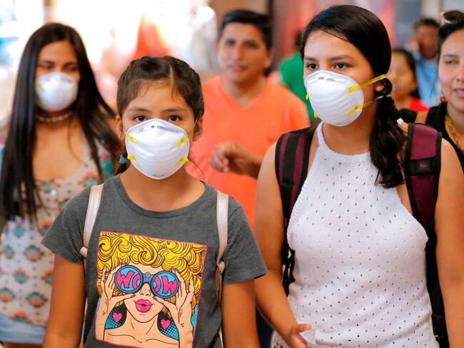 Unas personas con mascarillas salen desde el Aeropuerto de Lima