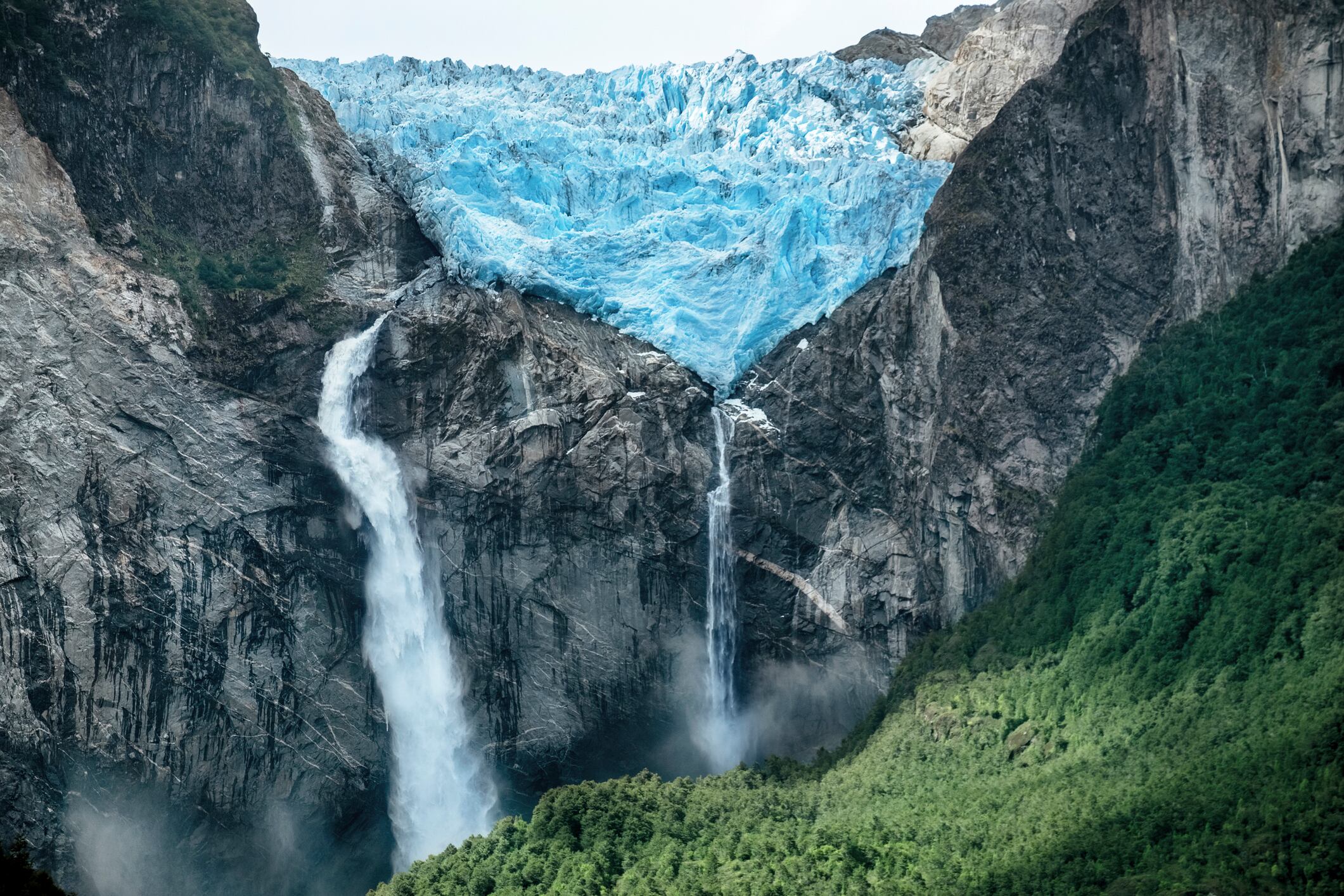 A huge Glacier melts to result in a huge waterfall splashing down the face of the Andes Mountains. Ventisquero Colgante de Queulat is the name of the Glacier and place. Or Queulat National Park.