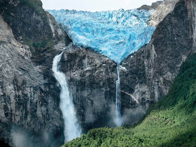 A huge Glacier melts to result in a huge waterfall splashing down the face of the Andes Mountains. Ventisquero Colgante de Queulat is the name of the Glacier and place. Or Queulat National Park.
