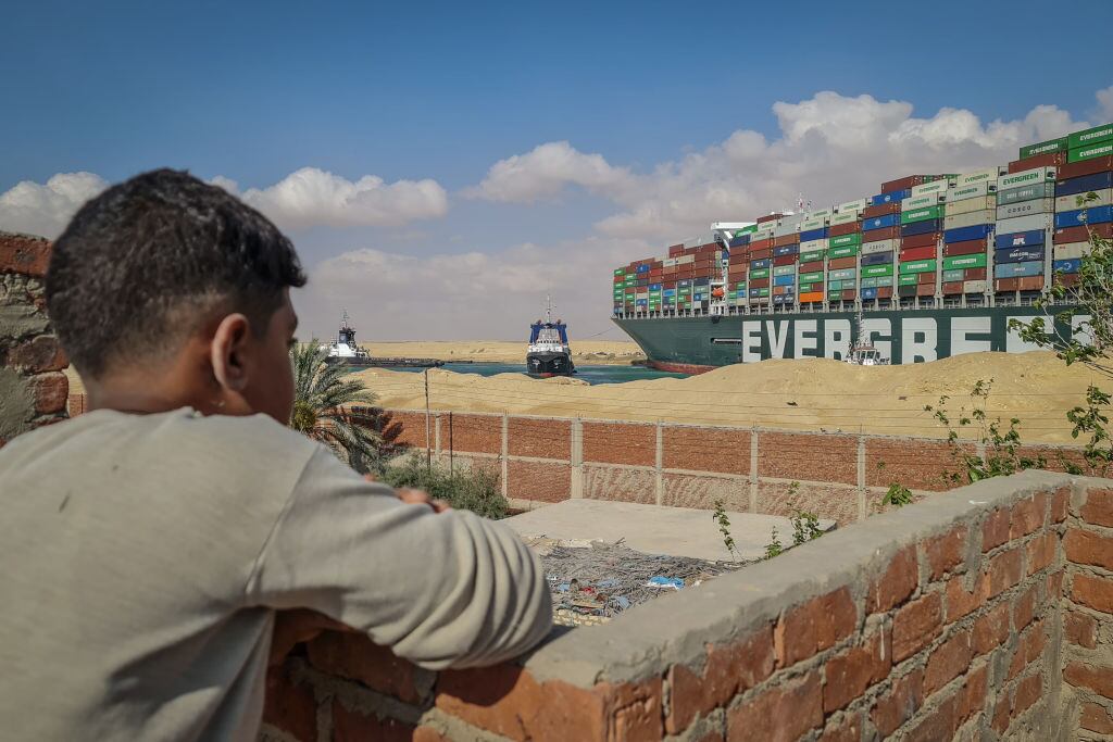 Un niño egipcio observa al Ever Given atrapado en el canal de Suez