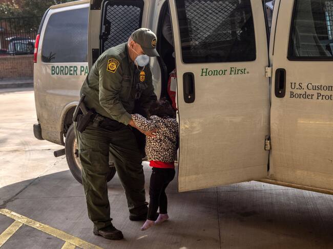 Un agente fronterizo transporta a un niño migrante en Texas