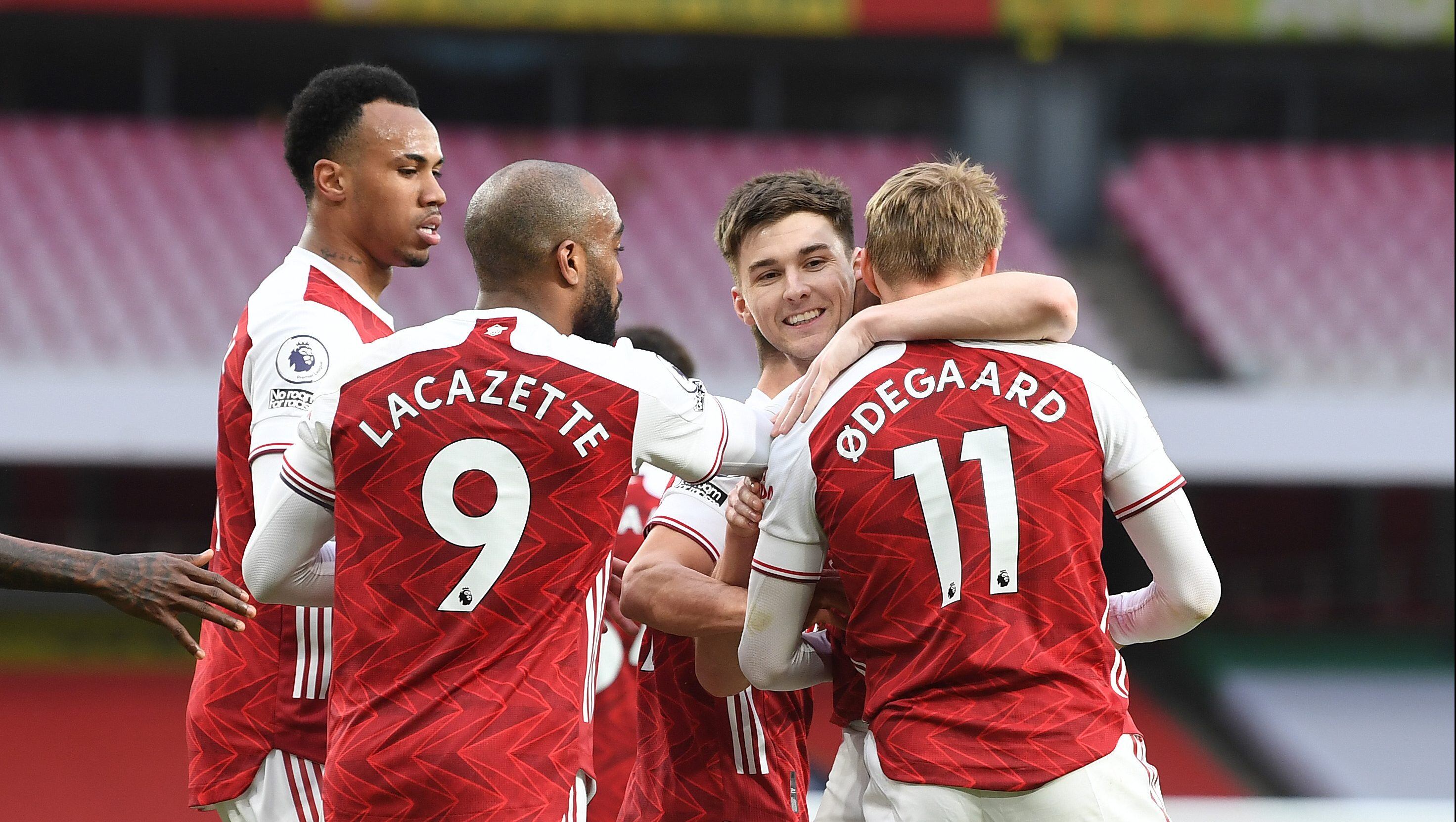 LONDON, ENGLAND - MARCH 14: (R) Martin Odegaard celebrates scoring the 1st Arsenal goal with (2ndR) Kieran Tierney, (L) Gabriel and (2ndR) Alex Lacazette during the Premier League match between Arsenal and Tottenham Hotspur at Emirates Stadium on March 14, 2021 in London, England. Sporting stadiums around the UK remain under strict restrictions due to the Coronavirus Pandemic as Government social distancing laws prohibit fans inside venues resulting in games being played behind closed doors.  (Photo by Stuart MacFarlane/Arsenal FC via Getty Images)