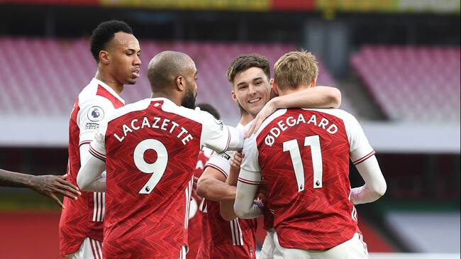 LONDON, ENGLAND - MARCH 14: (R) Martin Odegaard celebrates scoring the 1st Arsenal goal with (2ndR) Kieran Tierney, (L) Gabriel and (2ndR) Alex Lacazette during the Premier League match between Arsenal and Tottenham Hotspur at Emirates Stadium on March 14, 2021 in London, England. Sporting stadiums around the UK remain under strict restrictions due to the Coronavirus Pandemic as Government social distancing laws prohibit fans inside venues resulting in games being played behind closed doors. (Photo by Stuart MacFarlane/Arsenal FC via Getty Images)