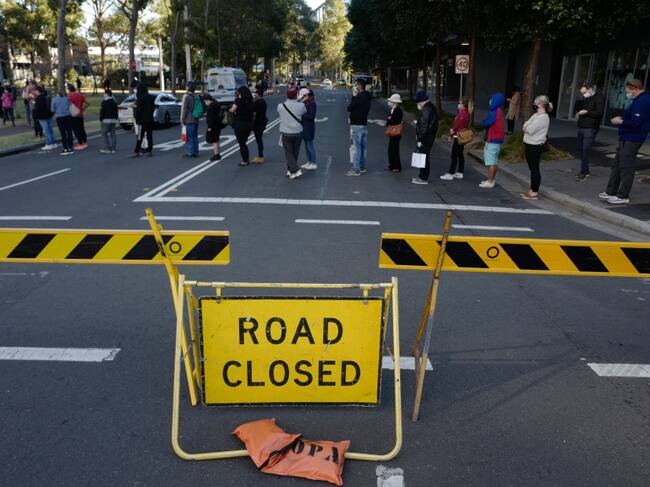 Personas hacen fila para vacunarse cerca de una calle cerrada en Sídney