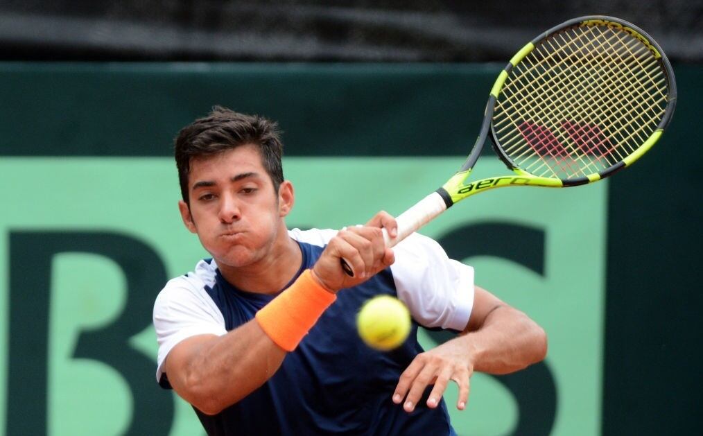 Chile's tennis player Christian Garin returns the ball to Colombia's Santiago Giraldo during their Davis Cup match in Medellin, Colombia on April 9, 2017. / AFP PHOTO / CAMILO GIL (Photo credit should read CAMILO GIL/AFP via Getty Images)