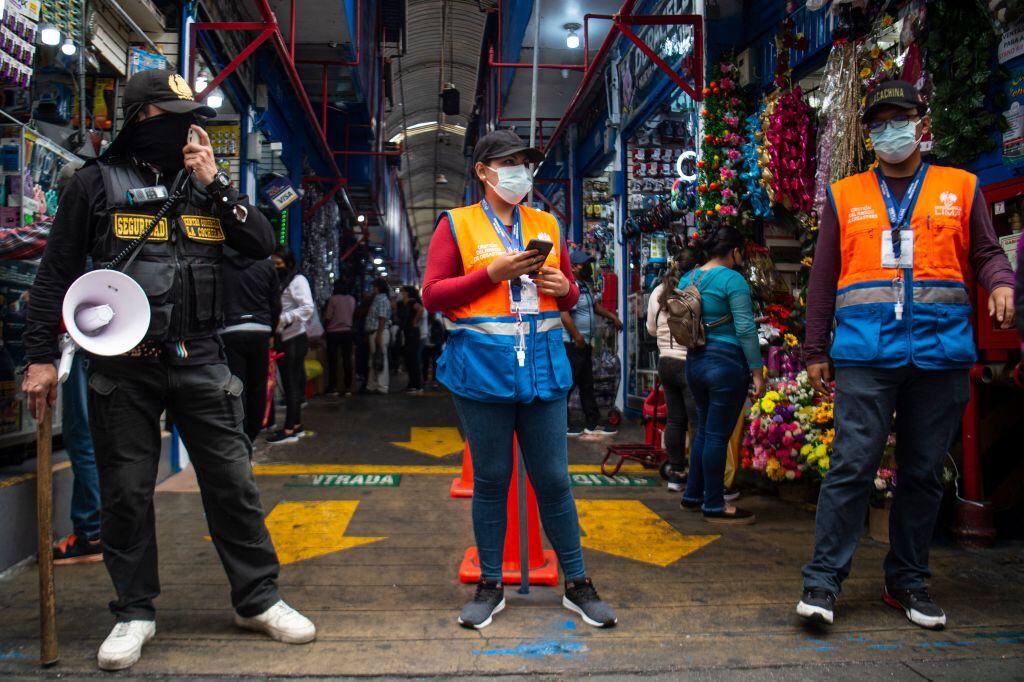 Personal de seguridad vigila el uso del carnet de vacunación en un local en Lima