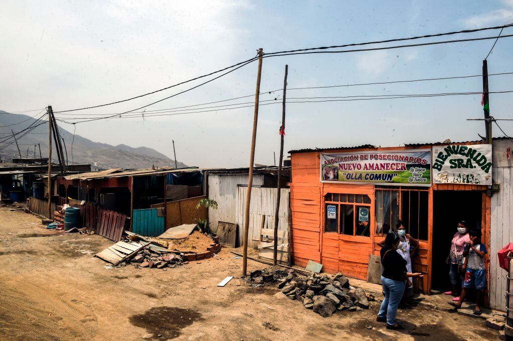 Personas conversan afuera de un comedor popular en Lima