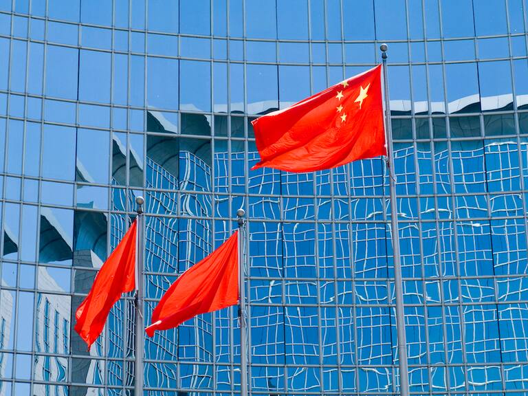 La bandera de China flamea ante un edificio en la ciudad de Pekín