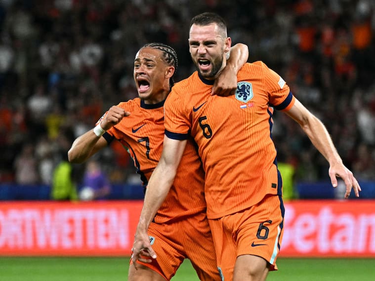 Netherlands' defender #06 Stefan de Vrij (R) celebrates with Netherlands' forward #07 Xavi Simons after scoring his team's first goal during the UEFA Euro 2024 quarter-final football match between the Netherlands and Turkey at the Olympiastadion in Berlin on July 6, 2024. (Photo by JAVIER SORIANO / AFP) (Photo by JAVIER SORIANO/AFP via Getty Images)