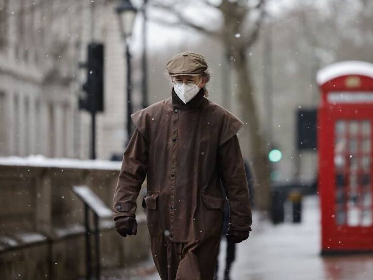 TOPSHOT - A man wearing a face mask because of the coronavirus pandemic walks in the street in London on February 8, 2021. (Photo by Tolga Akmen / AFP) (Photo by TOLGA AKMEN/AFP via Getty Images)