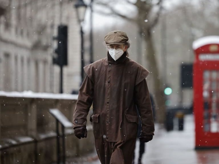 TOPSHOT - A man wearing a face mask because of the coronavirus pandemic walks in the street in London on February 8, 2021. (Photo by Tolga Akmen / AFP) (Photo by TOLGA AKMEN/AFP via Getty Images)