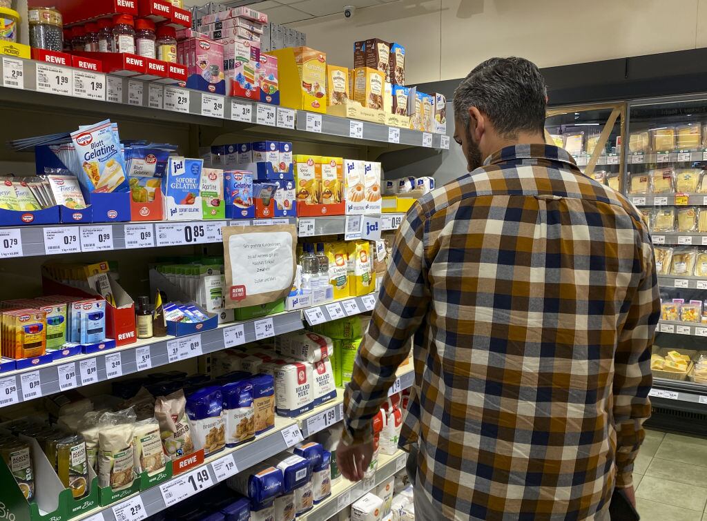 Un hombre revisa los precios antes de comprar en un mercado en Berlín