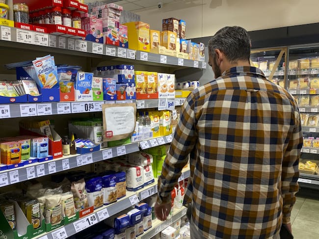Un hombre revisa los precios antes de comprar en un mercado en Berlín